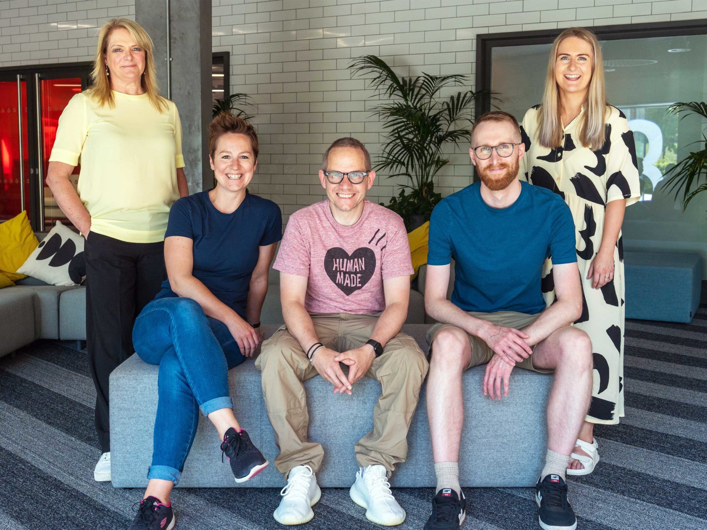 A team of research and visual designs poses in their office.